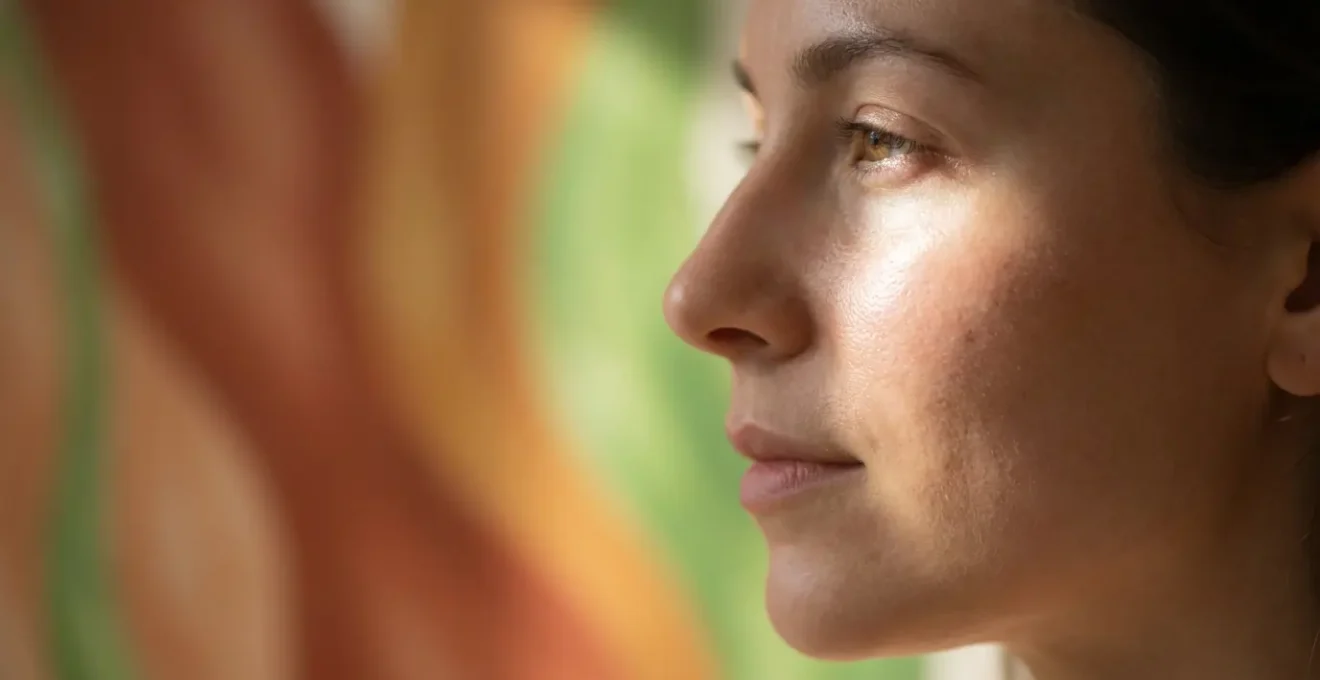 Portrait macro de profil d'une femme avec une peau lumineuse, superposition subtile de motifs végétaux abstraits