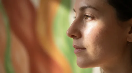 Portrait macro de profil d'une femme avec une peau lumineuse, superposition subtile de motifs végétaux abstraits